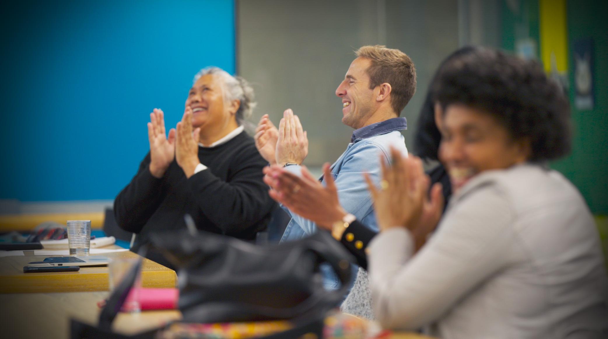 People applaud in a classroom