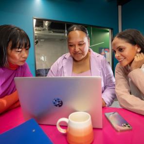 Yuka, Ash and Kate look at a laptop