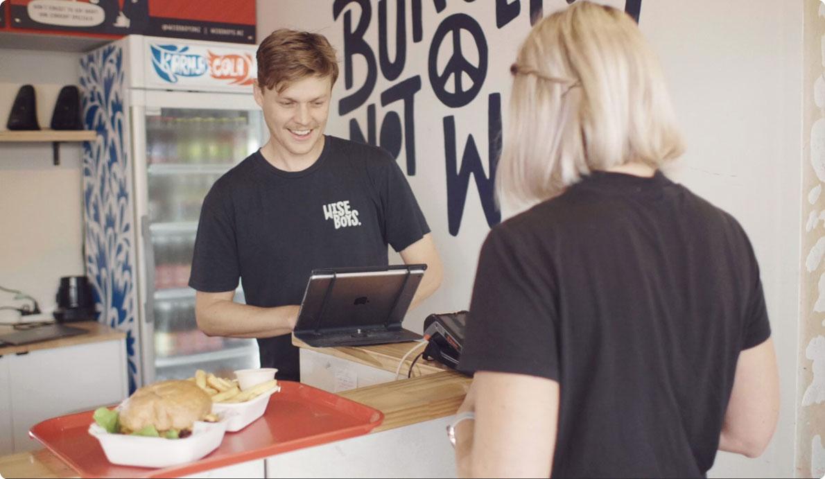 Customer at a cafe with the cashier using a tablet